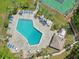Aerial view of community pool with lounge chairs, tennis court, and spa surrounded by lush landscaping at 168 Perimeter Ct # 5C, Deltona, FL 32725