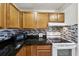 Kitchen featuring dark granite countertops, white appliances, and stylish tile backsplash at 168 Perimeter Ct # 5C, Deltona, FL 32725