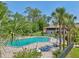Community pool surrounded by palm trees, lounge chairs, and well-maintained landscaping at 168 Perimeter Ct # 5C, Deltona, FL 32725