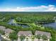 Scenic aerial view of townhomes overlooking a lush forest and a beautiful lake at 1757 Sunset Palm Dr, Apopka, FL 32712
