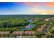 Scenic aerial view of townhomes nestled among lush greenery and a serene lake at sunset at 1757 Sunset Palm Dr, Apopka, FL 32712