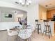 Open-concept dining area with a modern table set, kitchen view, and bright natural light at 1757 Sunset Palm Dr, Apopka, FL 32712