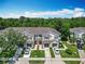 Exterior view of townhomes with individual driveways and attached garages, surrounded by mature trees at 1757 Sunset Palm Dr, Apopka, FL 32712