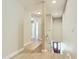 Bright hallway featuring wood floors leading to the entryway with stairs to lower level at 1757 Sunset Palm Dr, Apopka, FL 32712