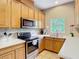 Well-lit kitchen featuring stainless steel appliances, light wood cabinets, and white countertops at 1757 Sunset Palm Dr, Apopka, FL 32712