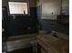 Enclosed bathroom with retro blue tiling, featuring a toilet, sink and vanity and a bathtub at 1822 Williams Manor Ave, Orlando, FL 32811