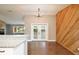 Bright dining area with wood accent wall, modern chandelier, and double doors leading to the exterior at 2320 Wekiva Ridge Rd, Apopka, FL 32712