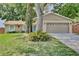 Charming single-story home featuring a well-manicured lawn, stone accents, and a two-car garage at 2320 Wekiva Ridge Rd, Apopka, FL 32712