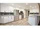 Modern kitchen featuring white cabinets, granite countertops, stainless steel appliances, and wood flooring at 2320 Wekiva Ridge Rd, Apopka, FL 32712