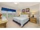 Cozy bedroom featuring a four-poster bed, side tables, and a window with natural light at 2346 Silver Palm Dr, Kissimmee, FL 34747