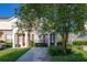 Charming townhome featuring a well-maintained lawn, mature trees, and inviting front entrance at 2346 Silver Palm Dr, Kissimmee, FL 34747