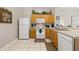 Functional kitchen featuring white appliances, tile flooring, and wood cabinets at 2346 Silver Palm Dr, Kissimmee, FL 34747