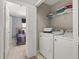 Convenient laundry room with washer, dryer, and storage shelving, next to bedroom at 2346 Silver Palm Dr, Kissimmee, FL 34747