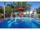 Community splash pad with bright blue flooring, shade umbrella, and multiple water features at 2346 Silver Palm Dr, Kissimmee, FL 34747