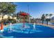A large community splash pad with a red umbrella, surrounding trees, and water features at 2346 Silver Palm Dr, Kissimmee, FL 34747
