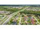 An aerial view of a sprawling residential area surrounded by lush greenery and roadways at 2445 Ravendale Ct, Kissimmee, FL 34758