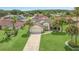 Aerial view of the property showcasing the house, driveway, lush lawn, and surrounding neighborhood at 2445 Ravendale Ct, Kissimmee, FL 34758