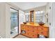 Bathroom featuring double sinks, wood cabinets, decorative lighting, and a tiled shower with a sliding glass door at 2445 Ravendale Ct, Kissimmee, FL 34758