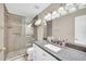 Elegant bathroom showcasing a granite countertop, tiled shower, modern fixtures, and ample lighting at 2445 Ravendale Ct, Kissimmee, FL 34758