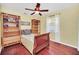 Bright bedroom with wood floors, a comfortable bed, a ceiling fan, built in shelving and a window with light drapes at 2445 Ravendale Ct, Kissimmee, FL 34758