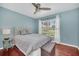 Cozy bedroom with hardwood floors, a comfortable bed, a ceiling fan, and a bright window with sheer curtains at 2445 Ravendale Ct, Kissimmee, FL 34758