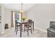 Dining area features a modern table, four chairs, neutral walls and floors and natural light at 2445 Ravendale Ct, Kissimmee, FL 34758