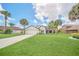 Beautiful home with lush green lawn, mature palm trees, and a long driveway leading to the garage at 2445 Ravendale Ct, Kissimmee, FL 34758