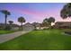 Dusk view of home with well-maintained lawn, palm trees, and a cozy, inviting exterior at 2445 Ravendale Ct, Kissimmee, FL 34758