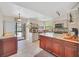 Open kitchen with dark wood cabinets, granite countertops and stainless appliances, with view to backyard pool area at 2445 Ravendale Ct, Kissimmee, FL 34758