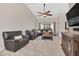 Inviting living room with vaulted ceiling, ceiling fan, large sectional sofa, and media cabinet at 2445 Ravendale Ct, Kissimmee, FL 34758