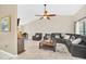 Spacious living room with a leather sectional sofa, ceiling fan, and an adjacent dining area at 2445 Ravendale Ct, Kissimmee, FL 34758