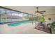 Beautiful screened-in pool with outdoor dining and ceiling fans overlooking the lush backyard at 2445 Ravendale Ct, Kissimmee, FL 34758