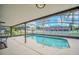 Inviting screened-in pool surrounded by a spacious patio and lush landscaping, perfect for outdoor relaxation at 2445 Ravendale Ct, Kissimmee, FL 34758