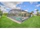 A screened-in pool providing an outdoor oasis with surrounding green lawn at 2445 Ravendale Ct, Kissimmee, FL 34758