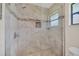 Modern tiled shower with a glass door, rainfall showerhead, mosaic accent tiles, and a built-in niche at 2445 Ravendale Ct, Kissimmee, FL 34758