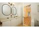 Bright bathroom featuring double sinks, a tall storage cabinet, and a peek into a sunny bedroom at 2493 Lancien Ct # 5, Orlando, FL 32826