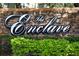 The Enclave community sign is surrounded by lush greenery, making it a welcoming entrance at 2493 Lancien Ct # 5, Orlando, FL 32826