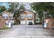 Exterior facade of the townhome featuring a private balcony, attached garage, and secure gated entry at 2493 Lancien Ct # 5, Orlando, FL 32826