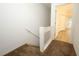 Carpeted staircase and hallway leading to a bright room with wood-look floors, offering a welcoming transition at 2493 Lancien Ct # 5, Orlando, FL 32826