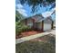 Cozy home with red brick details and a neatly mulched front garden at 2723 Talladega Dr, Orlando, FL 32826