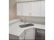 Modern kitchen sink featuring stainless steel basin, white cabinets, and stone countertops at 2723 Talladega Dr, Orlando, FL 32826