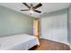 Light-filled bedroom featuring wood floors, a ceiling fan, double closet and modern paint at 2945 Lake Pineloch Blvd # 18-26, Orlando, FL 32806
