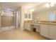 Spacious bathroom featuring double vanity, glass shower, and beige tile at 2985 Buccaneer Palm Rd, Kissimmee, FL 34747