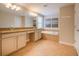 Bathroom featuring soaking tub, double vanity, tile floors, and beige cabinets at 2985 Buccaneer Palm Rd, Kissimmee, FL 34747