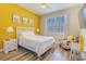 Bright bedroom featuring yellow accent wall, white furniture, and natural light at 2985 Buccaneer Palm Rd, Kissimmee, FL 34747
