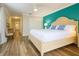 Bright bedroom featuring hardwood floors, furniture, and blue accent wall at 2985 Buccaneer Palm Rd, Kissimmee, FL 34747