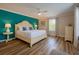 Bright bedroom featuring hardwood floors, furniture, and blue accent wall at 2985 Buccaneer Palm Rd, Kissimmee, FL 34747