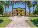 Stately community clubhouse entrance framed by majestic palm trees and manicured lawns at 2985 Buccaneer Palm Rd, Kissimmee, FL 34747