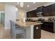 Modern kitchen featuring dark cabinetry, granite countertops, and stainless appliances at 2985 Buccaneer Palm Rd, Kissimmee, FL 34747