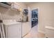 Bright laundry room with white appliances and convenient shelving for storage at 2985 Buccaneer Palm Rd, Kissimmee, FL 34747